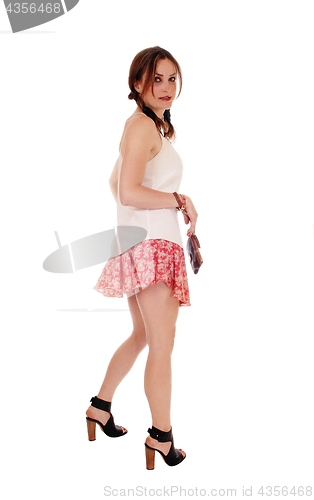 Image of Young lovely woman in shorts looking back