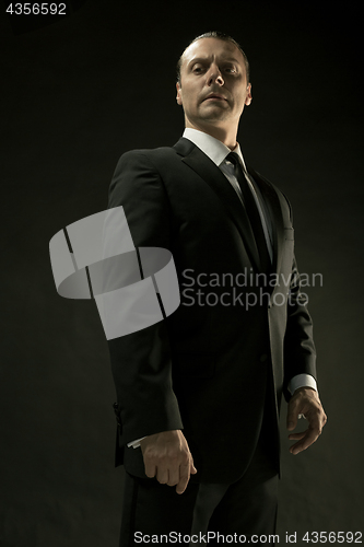 Image of The attractive man in black suit on dark background