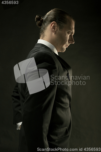 Image of The attractive man in black suit on dark background