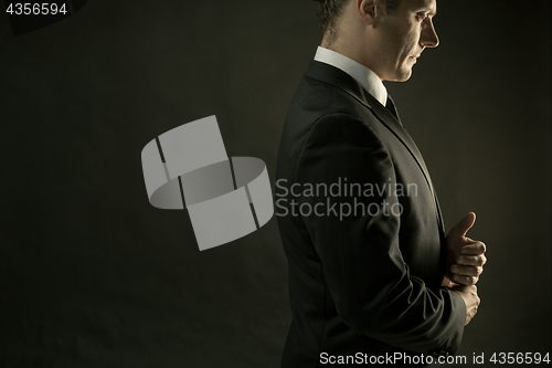 Image of The attractive man in black suit on dark background