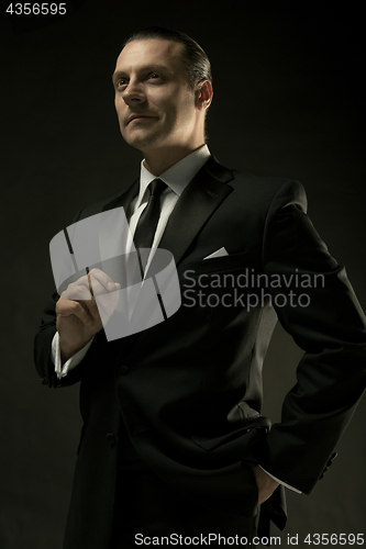 Image of The attractive man in black suit on dark background