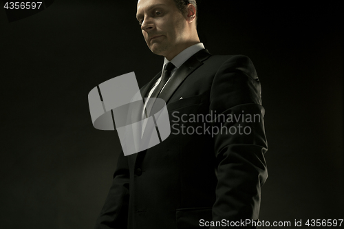 Image of The attractive man in black suit on dark background