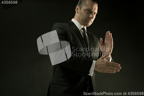 Image of The attractive man in black suit on dark background