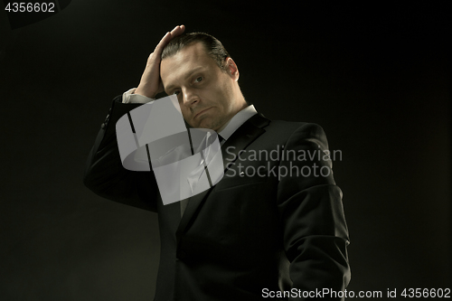 Image of The attractive man in black suit on dark background