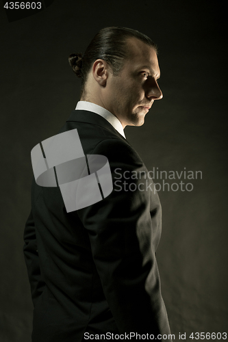 Image of The attractive man in black suit on dark background