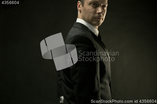 Image of The attractive man in black suit on dark background