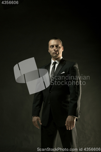 Image of The attractive man in black suit on dark background