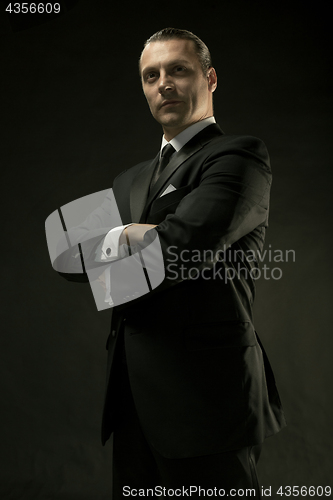 Image of The attractive man in black suit on dark background