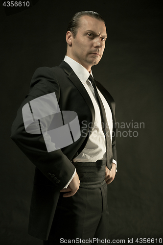 Image of The attractive man in black suit on dark background