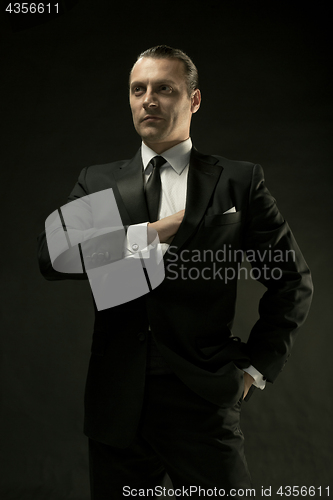 Image of The attractive man in black suit on dark background