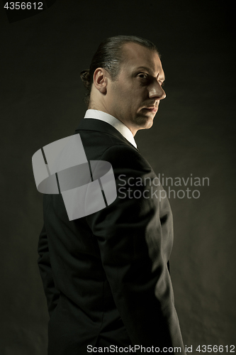 Image of The attractive man in black suit on dark background