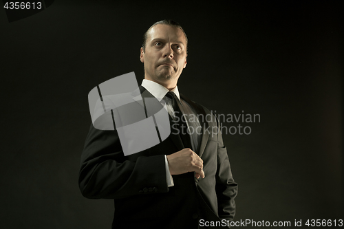 Image of The attractive man in black suit on dark background