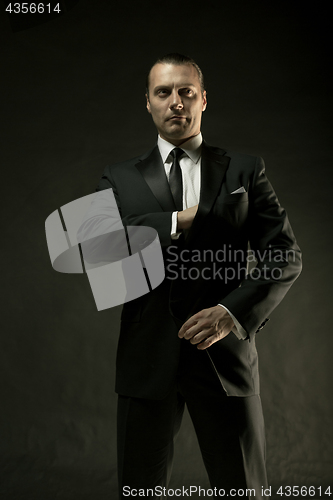 Image of The attractive man in black suit on dark background