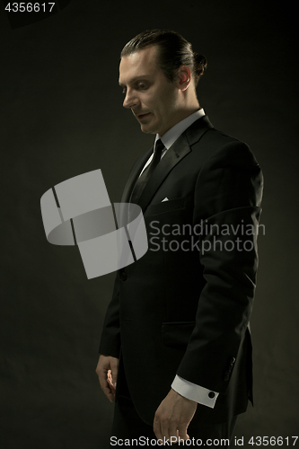 Image of The attractive man in black suit on dark background