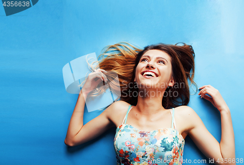 Image of young pretty woman fooling around on blue background