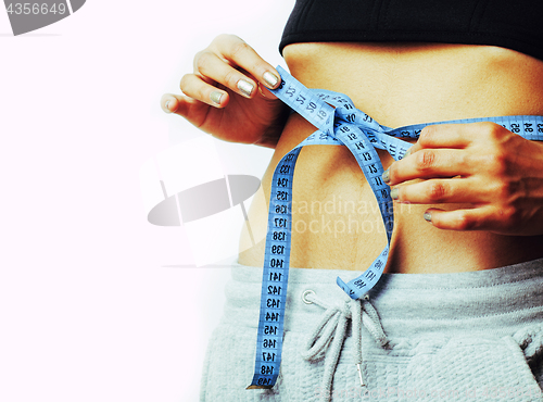 Image of woman measuring waist with tape on knot like a gift, african tan