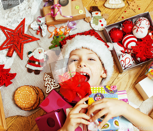 Image of little cute boy with Christmas gifts at home. close up emotional