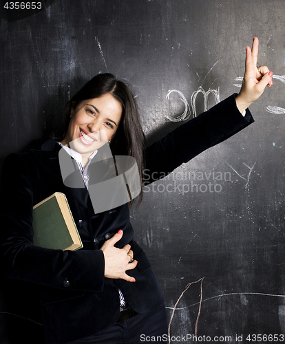 Image of portrait of happy cute student at blackboard