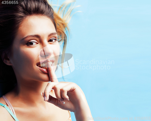 Image of young pretty woman fooling around on blue background