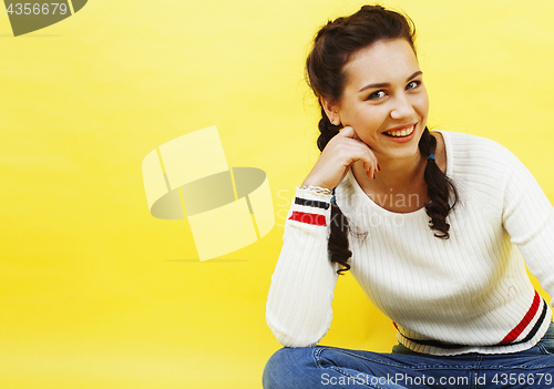 Image of lifestyle people concept: pretty young school teenage girl having fun happy smiling on yellow background