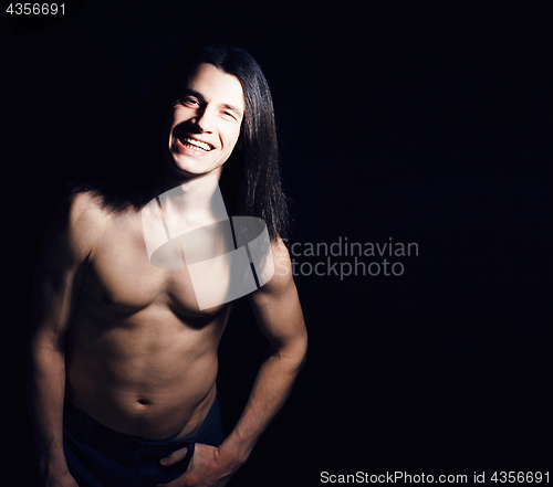 Image of handsome young man with long hair naked torso on black background