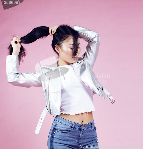 Image of young pretty smiling asian korean girl wearing modern fashion clothers on pink background, lifestyle people concept closeup