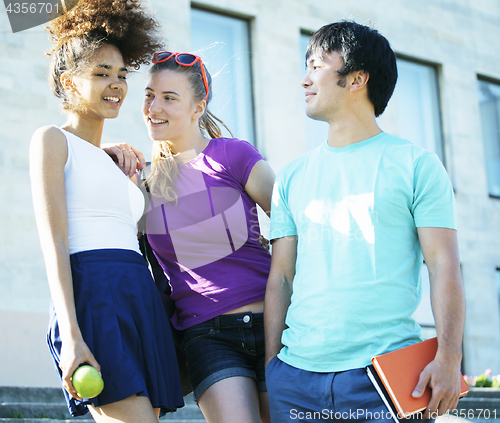 Image of cute group of teenages at the building of university with books huggings, back to school