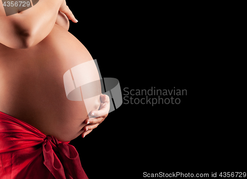 Image of Beautyful Naked Pregnant woman caressing her belly