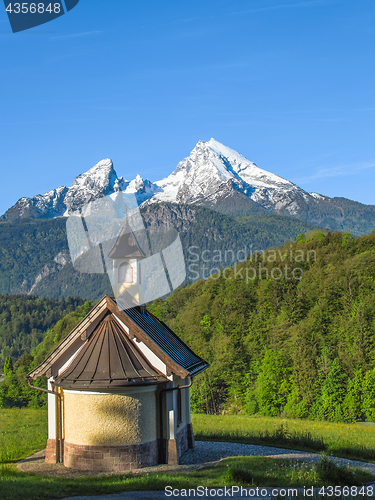 Image of Vertical view of small chapel and snowy summit of Watzmann mount