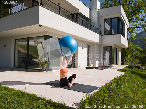 Image of woman doing exercise with pilates ball