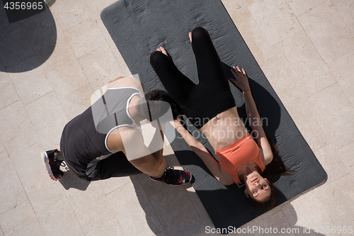 Image of woman with personal trainer doing morning yoga exercises top vie