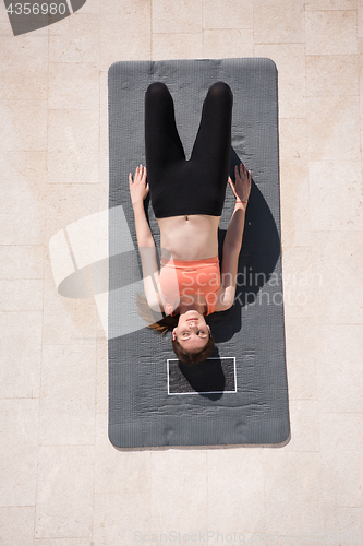 Image of woman doing morning yoga exercises top view