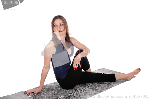 Image of Exercising woman sitting on floor, resting