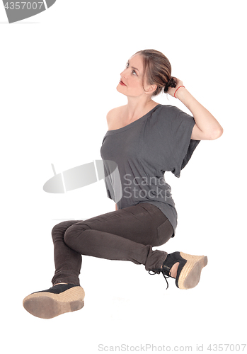 Image of Young woman sitting on floor and looking up