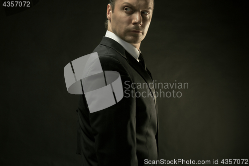 Image of The attractive man in black suit on dark background