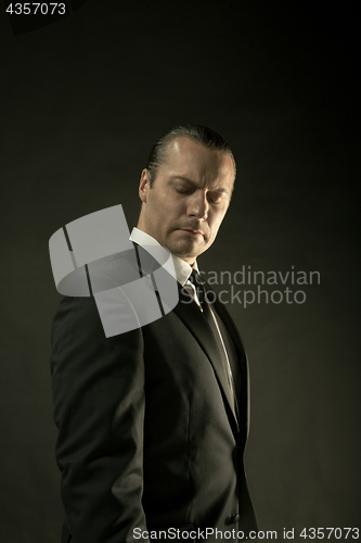 Image of The attractive man in black suit on dark background