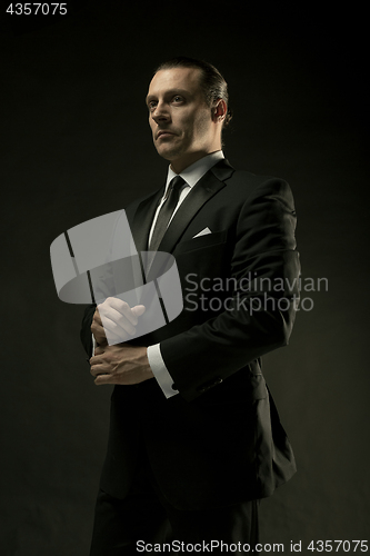 Image of The attractive man in black suit on dark background