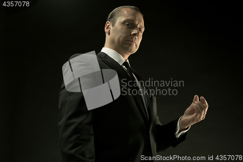 Image of The attractive man in black suit on dark background