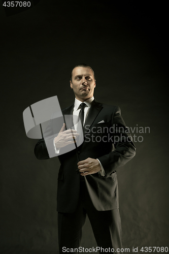 Image of The attractive man in black suit on dark background