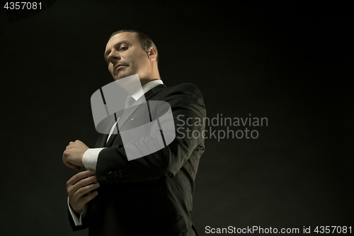 Image of The attractive man in black suit on dark background