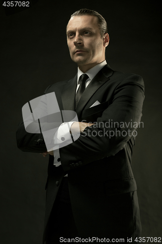 Image of The attractive man in black suit on dark background