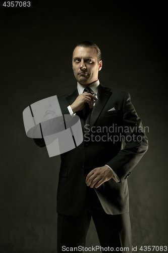 Image of The attractive man in black suit on dark background