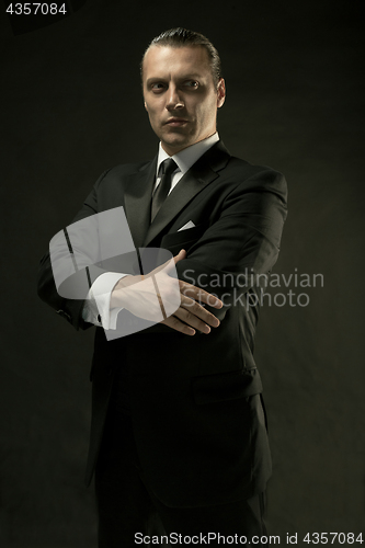 Image of The attractive man in black suit on dark background