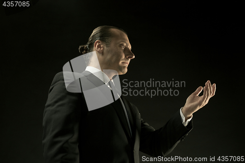 Image of The attractive man in black suit on dark background