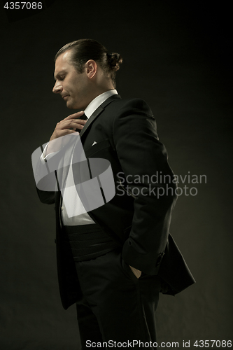 Image of The attractive man in black suit on dark background