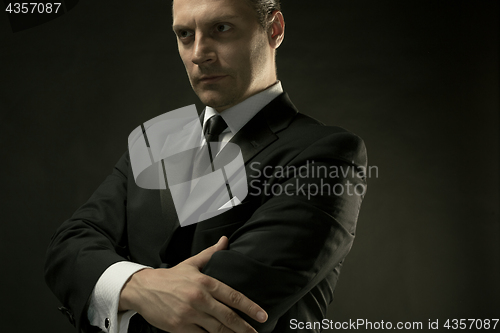 Image of The attractive man in black suit on dark background