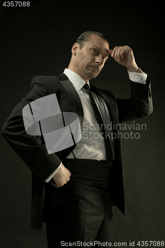 Image of The attractive man in black suit on dark background