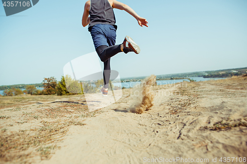 Image of Running sport. Man runner sprinting outdoor in scenic nature. Fit muscular male athlete training trail running for marathon run.