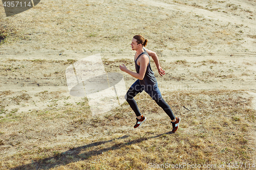 Image of Running sport. Man runner sprinting outdoor in scenic nature. Fit muscular male athlete training trail running for marathon run.