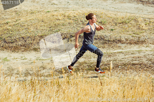 Image of Running sport. Man runner sprinting outdoor in scenic nature. Fit muscular male athlete training trail running for marathon run.